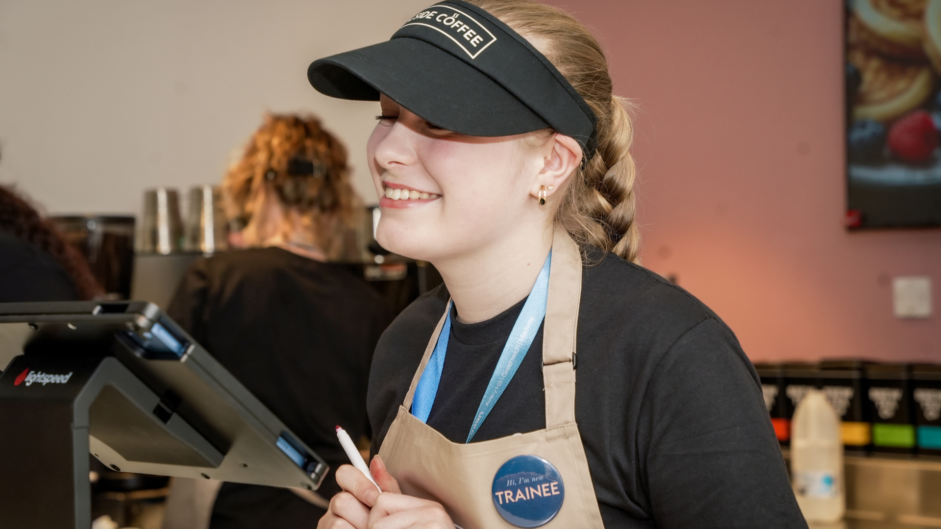 student staff serving a coffee smiling